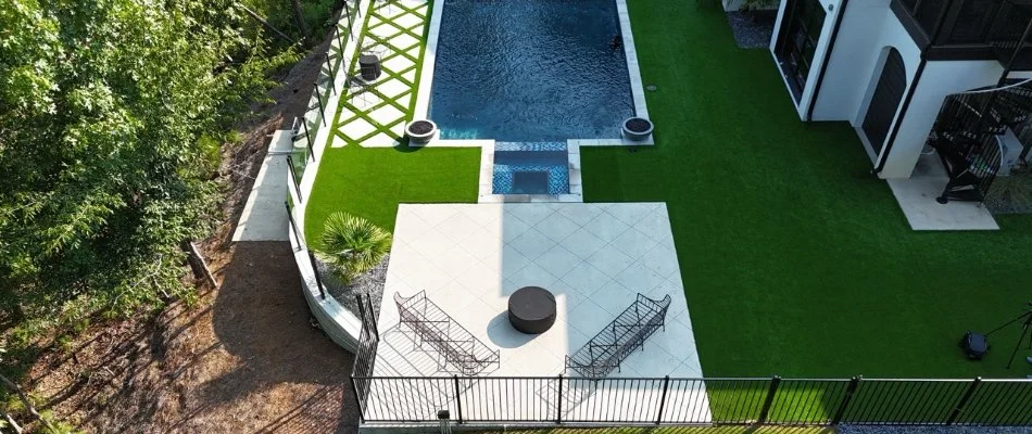 Outdoor living space with pool and artificial turf in Homewood, AL.