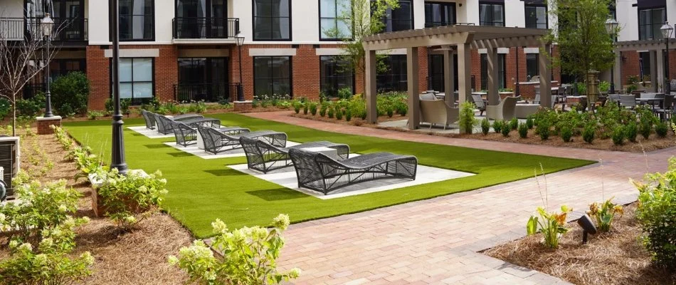 An apartment outdoor space in Mountain Brook, AL, with turf, plants, and seating.