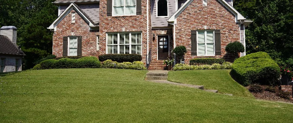 A brick house in Mountain Brook, AL, with a green lawn and walkway.