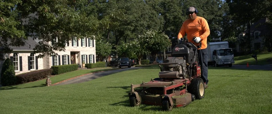 Crew on a mower mowing a lawn in Harvest, AL.
