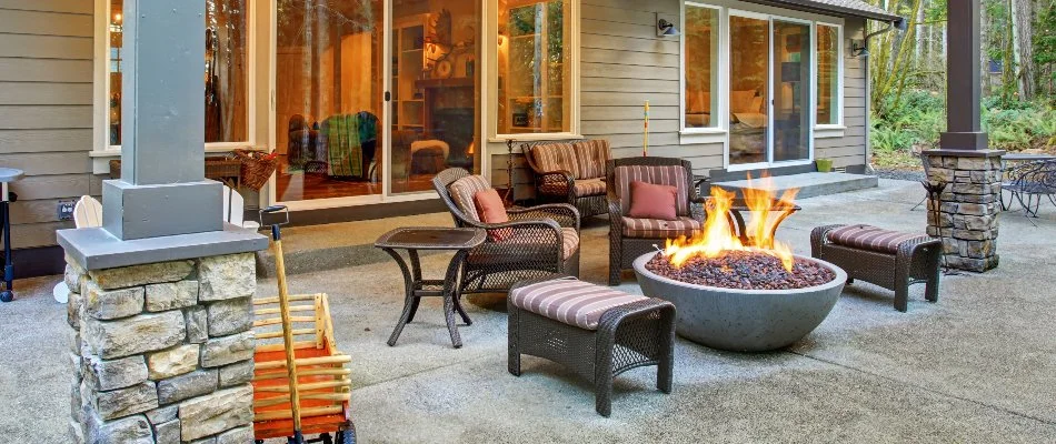 Fire pit in Mountain Brook, AL, with furniture in a backyard.