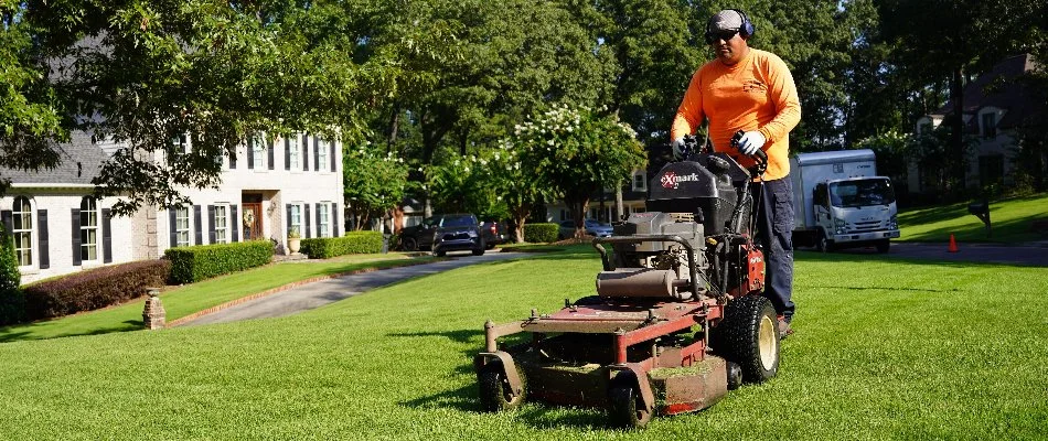 Lawn care professional mowing a lawn in Liberty Park, AL.