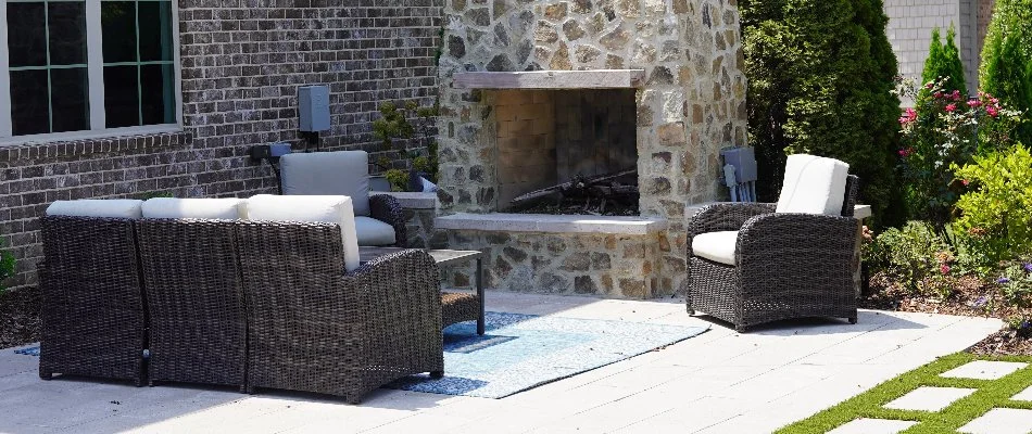 Outdoor fireplace in Mountain Brook, AL, with chairs and landscape plants.