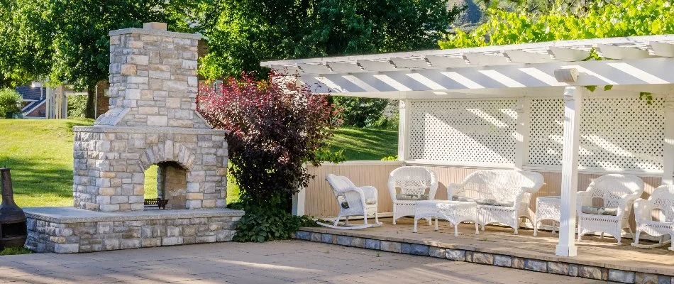 Outdoor fireplace in Mountain Brook, AL, on a patio with chairs.