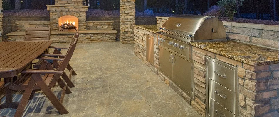Outdoor kitchen next to an outdoor fireplace in Mountain Brook, AL.
