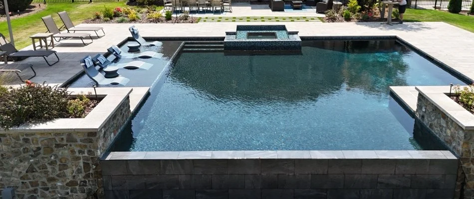 Pool with hot tub and large deck on a property in Mountain Brook, AL.