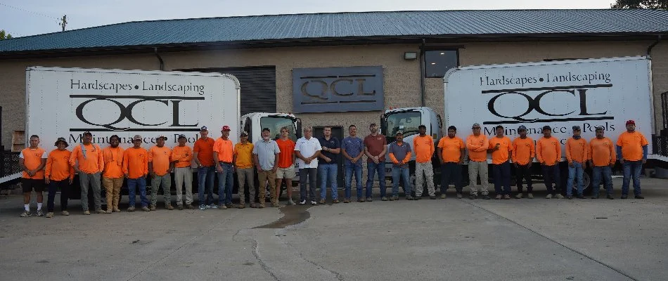 QCL team in Mountain Brook, AL, standing in front of two trucks.