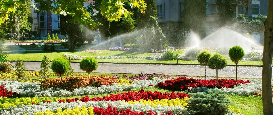 Sprinkler irrigation on a landscape in Moores Mill, AL, with flowers.