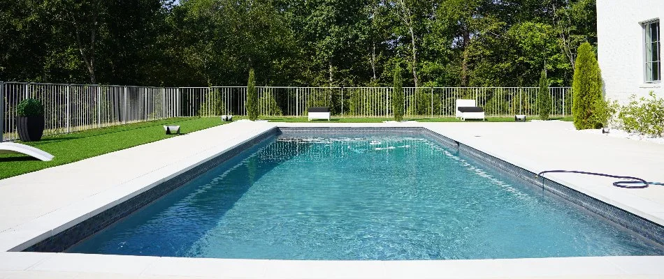 Swimming pool with trees in background on a property in Mountain Brook, AL.