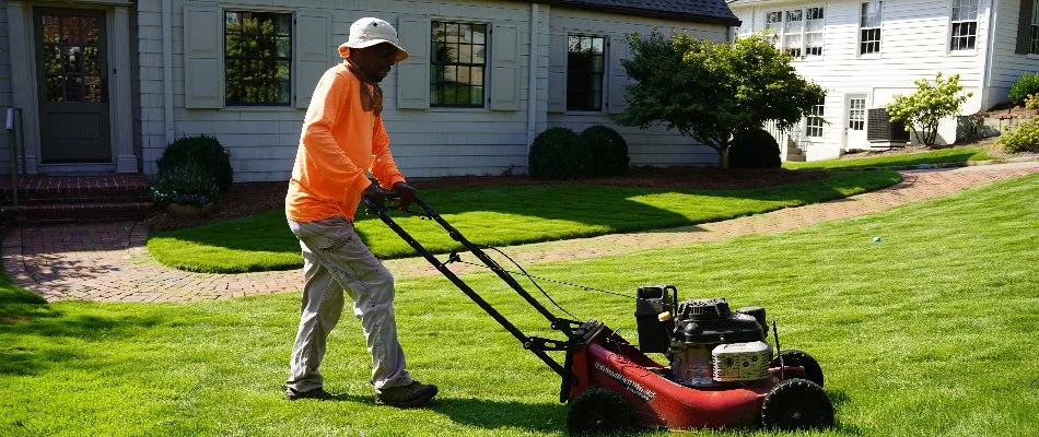 Worker in Big Cove, AL, pushing a lawn mower.