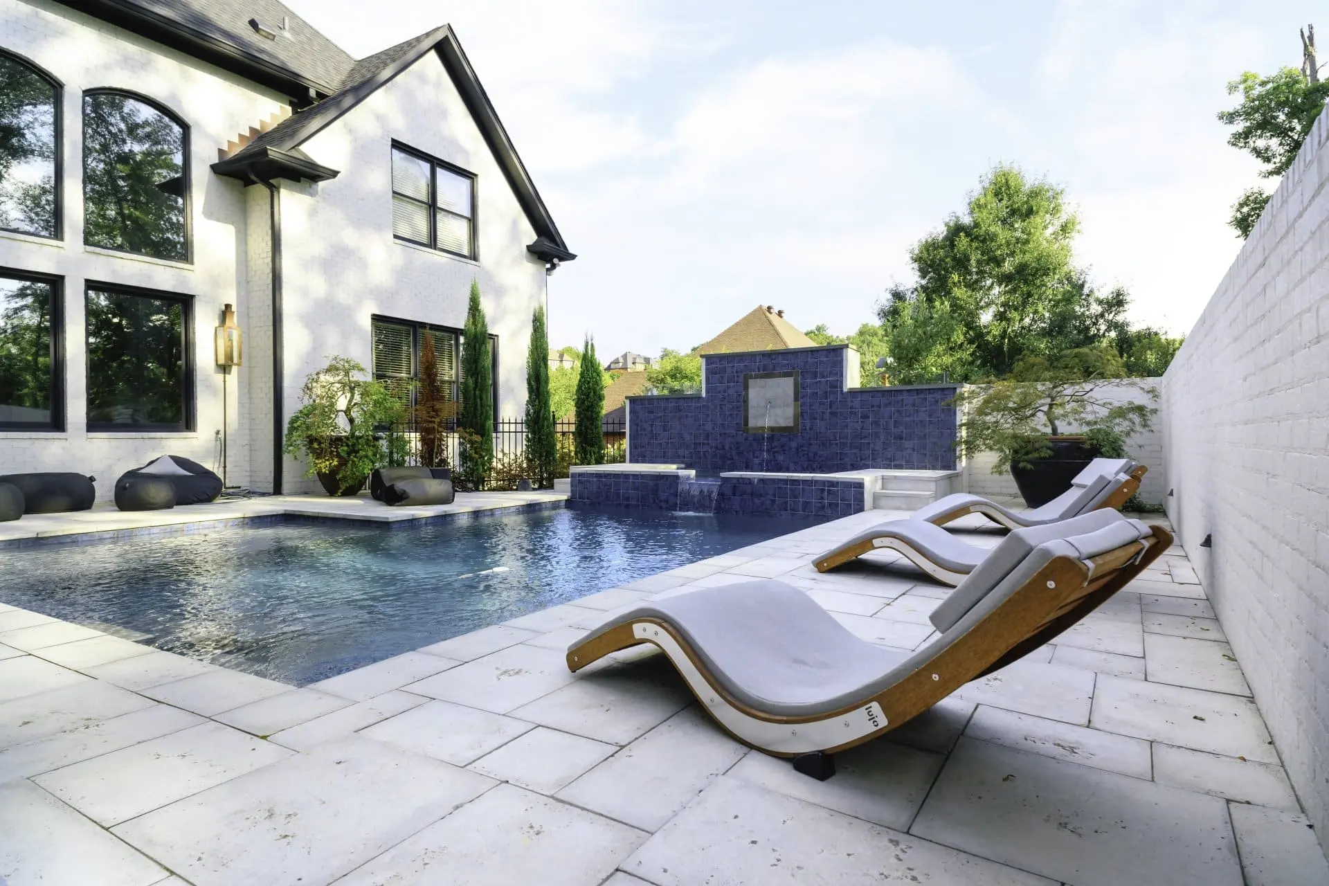 Pool with sun deck and chairs on paver patio at a home in Liberty Park, AL.