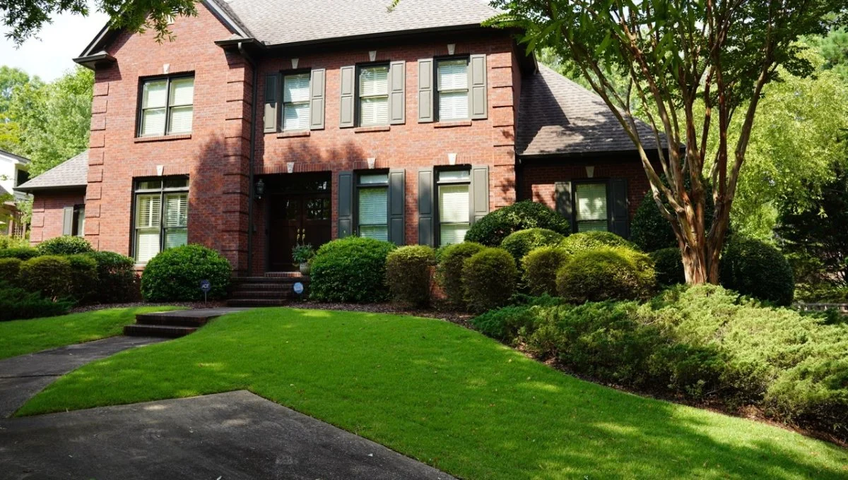 Brick house with grass and plants in landscape.